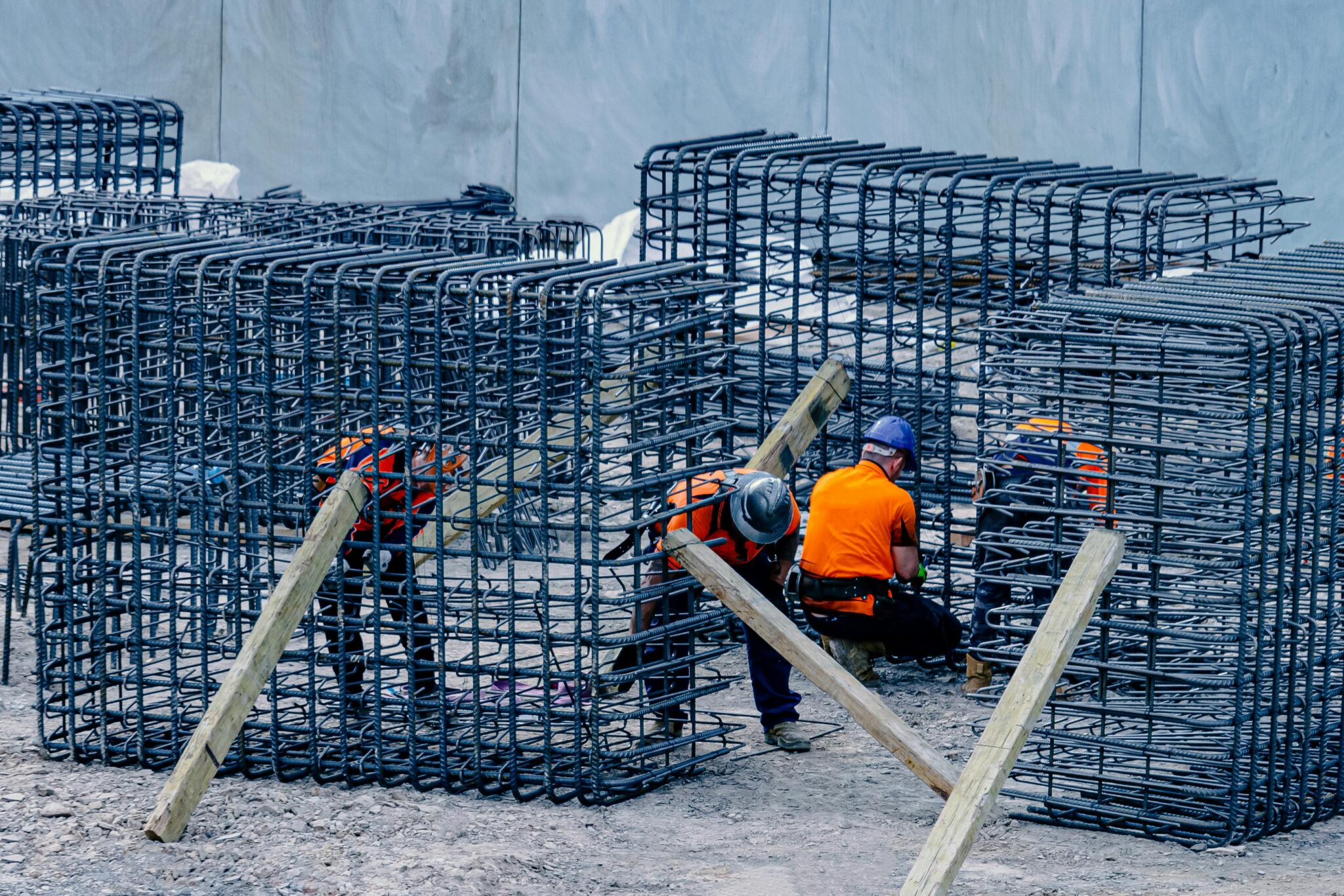 Construction workers assembling steel frames at a site, ensuring structural integrity.